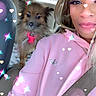 person, dog, car_interior, seatbelt, pink_hoodie, fluffy_dog, pet, window, seat, casual, portrait, cute, sparkle_effect, heart_effect, indoor, smile, animal, companion, canine, friendship