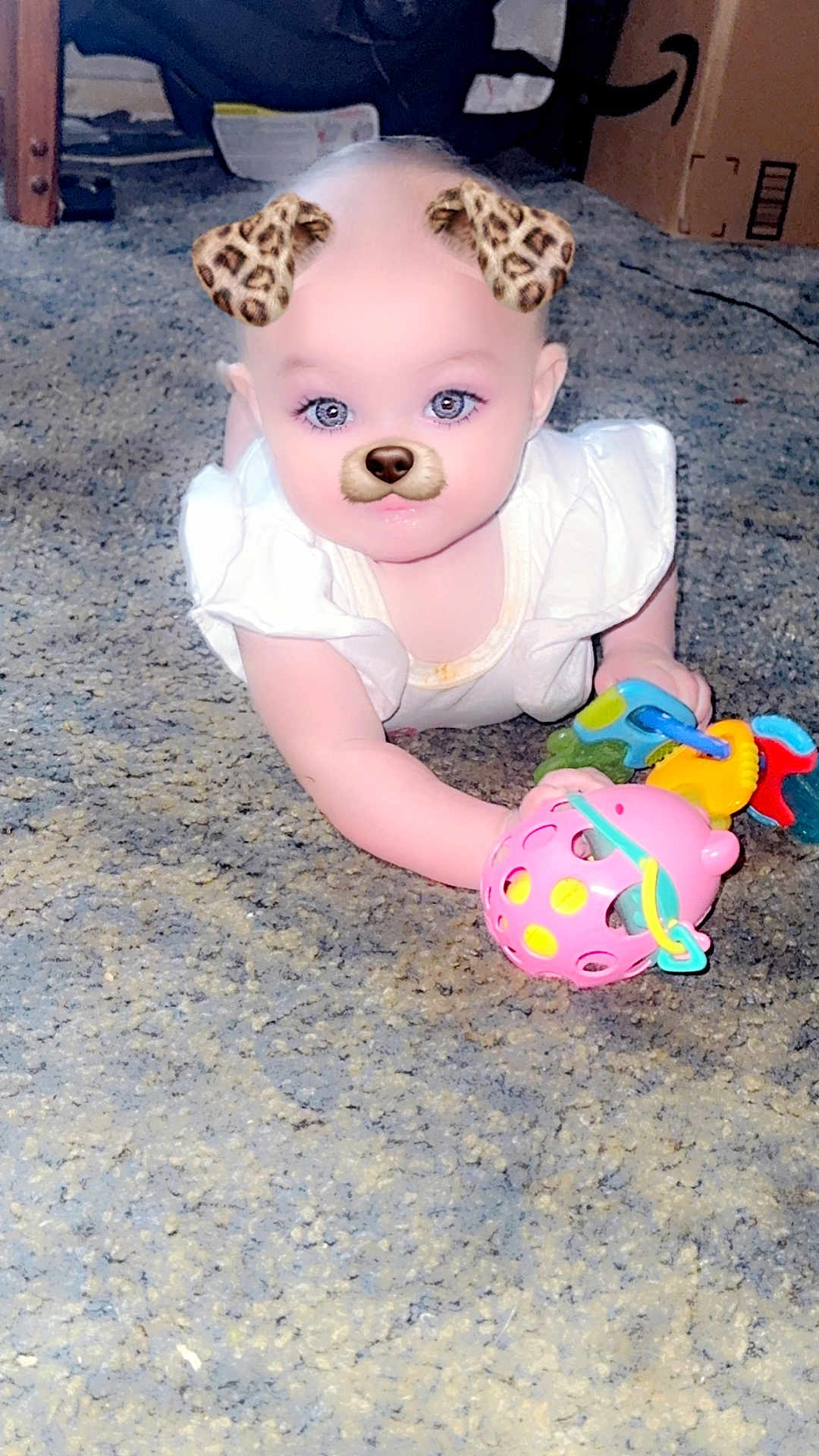 Willow joined the competition — help win amazing prizes! baby, infant, crawling, toy, carpet, indoor, child, face_filter, dog_filter, leopard_ears, cute, playful, white_clothing, colorful_toys, hand, expression, young_child, person, floor, fun