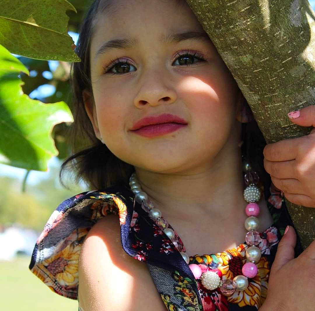 Christiana is registered to the contest to win money with this photo: black_hair, child, cool, eye, eyebrow, eyelash, face, finger, gesture, grass, hairstyle, happy, hat, iris, joy, lip, people_in_nature, person, skin, summer