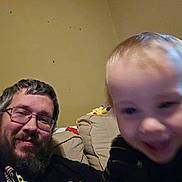 Xander joined the competition — help win amazing prizes! man, child, toddler, beard, glasses, couch, indoor, plush_toy, pikachu, smile, motion_blur, casual, striped_clothing, living_room, happy, portrait, person, furniture, relaxed, home