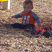 Ryker joined the competition — help win amazing prizes! child, toddler, boy, playground, wood_chips, mulch, toy_car, orange_shirt, long_sleeves, sitting, bare_feet, face, hair, outdoor, sunlight, shadow, toy, playing, ground, casual_clothing
