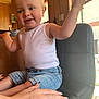 Finley is registered to the contest to win money with this photo: toddler, child, smiling, white_tank_top, denim_shorts, sitting, black_chair, hand, indoor, wooden_interior, natural_light, happy, cute, person, casual_clothing, young_child, waving, portrait, cozy, support