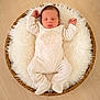 baby, newborn, infant, sleeping, onesie, basket, woven_basket, faux_fur, fur_rug, cozy, soft_texture, wood_floor, top_down_view, portrait, peaceful, nursery, tiny, cute, hands_up, white_clothing