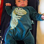 Elyo a rejoint le concours — aidez-le/la à gagner de superbes lots ! baby, newborn, infant, onesie, dinosaur, towel, blanket, pacifier, lying_down, eyes_open, small_hand, portrait, indoor, soft_light, cozy, cute, fabric, bed, nap_time, gaze