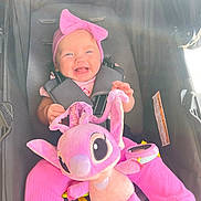 Paisley joined the competition — help win amazing prizes! baby, child, smiling, pink_bow, headband, plush_toy, purple_toy, stroller, seatbelt, pink_pants, happy, infant, cute, toy, portrait, baby_clothing, child_in_stroller, daylight, sunlight, indoors
