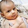baby, infant, face, eyes, blanket, knit_blanket, hand, ear, skin, portrait, close_up, expression, curious, newborn, wrapped, soft_texture, cozy, bedding, indoors, eyelashes