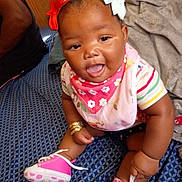 Journey is registered to the contest to win money with this photo: baby, child, smiling, indoor, pink_shoes, headband, bows, blanket, bib, cute, happy, person, clothing, sitting, infant, footwear, patterned, accessory, portrait, cute_face