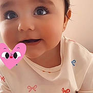 Chiara participe au concours pour gagner de l'argent avec cette photo : adorable, baby, bow_pattern, cartoon_sticker, child, close_up, cute, expression, eyes, face, indoors, infant, person, pink_heart_sticker, portrait, shirt, skin, smile, white_clothing, young_child