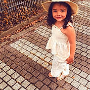 Ruby participe au concours pour gagner de l'argent avec cette photo : autumn_leaves, brick, casual, child, curly_hair, cute, daylight, fence, girl, happy, hat, nature, outdoor, pavement, portrait, sandals, smile, standing, summer_clothing, young