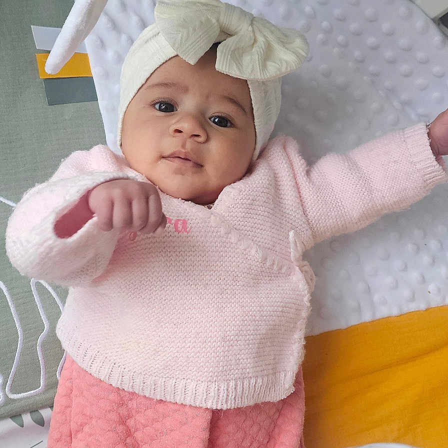 Kyara a rejoint le concours — aidez-le/la à gagner de superbes lots ! baby, infant, crib, toy, headband, pink_clothing, blanket, soft_texture, cute, child, indoors, playful, reaching, face, person, sleeping_area, comfort, toddler, apparel, resting