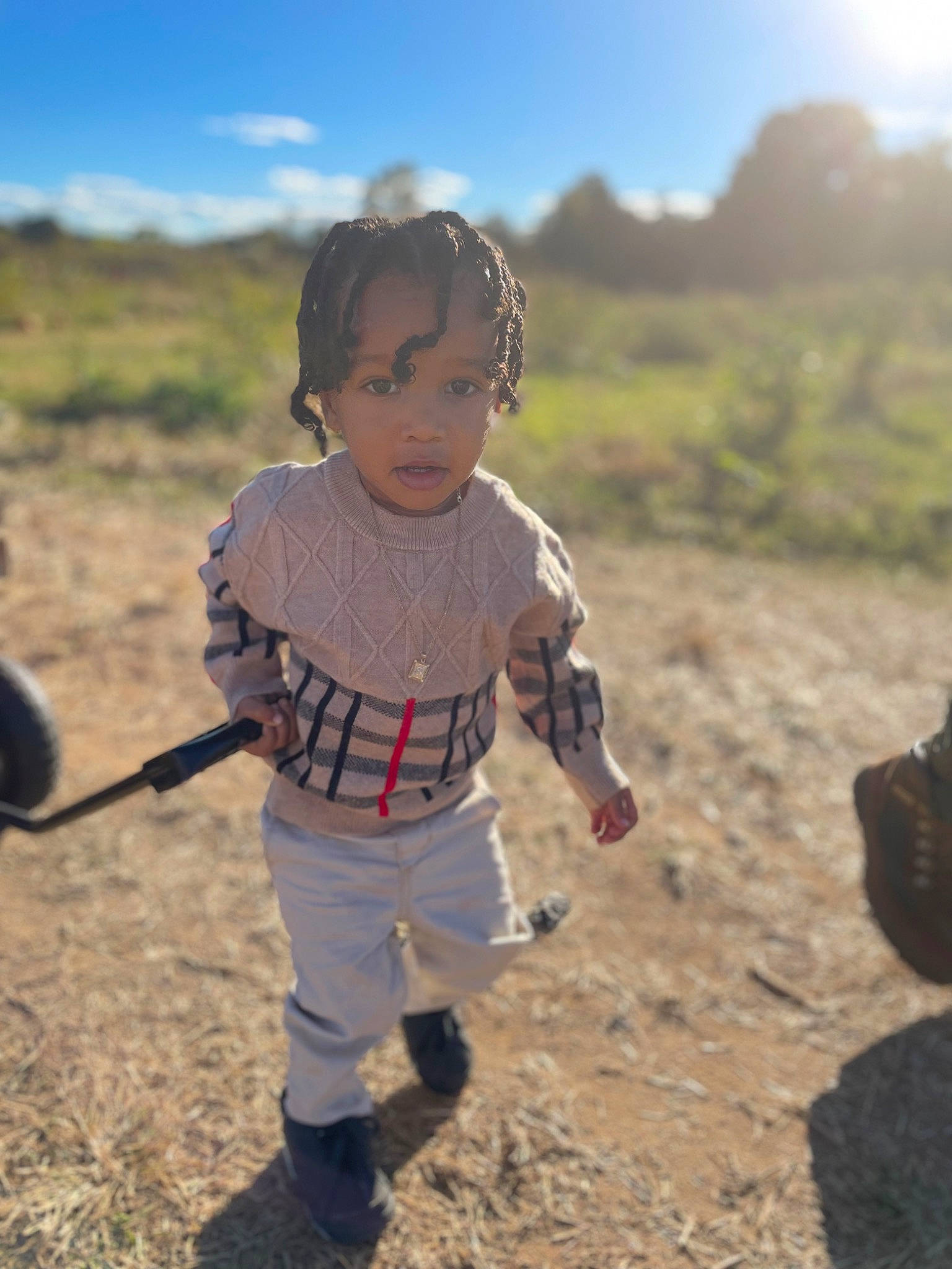 Syre is registered to the contest to win money with this photo: baby_toddler_clothing, child, cloud, field, fun, grass, grassland, happy, landscape, mud, people_in_nature, person, play, prairie, recreation, sand, shadow, sitting, sky, soil