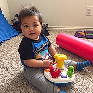 Aaron joined the competition — help win amazing prizes! black_and_blue_shirt, blue_foam_mat, carpet, child, colorful, cute, floor, gray_pants, happy, indoor, light_switch, person, pink_foam_roller, playtime, smiling, socks, toddler, toy, wall, young_child
