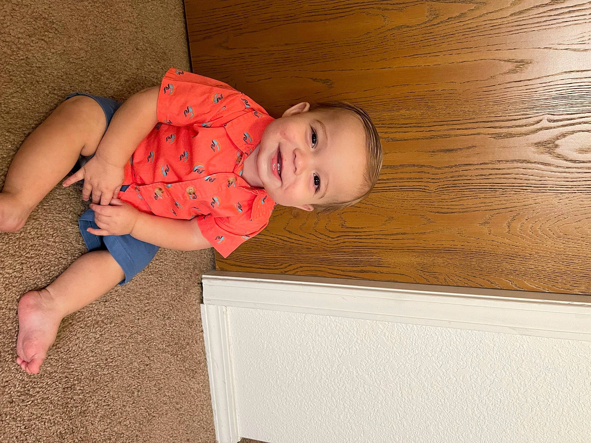 Ezra is registered to the contest to win money with this photo: baby, baby_toddler_clothing, cheek, child, comfort, eye, floor, flooring, foot, fun, hardwood, human_body, human_leg, joy, pattern, person, skin, sleeve, smile, toddler