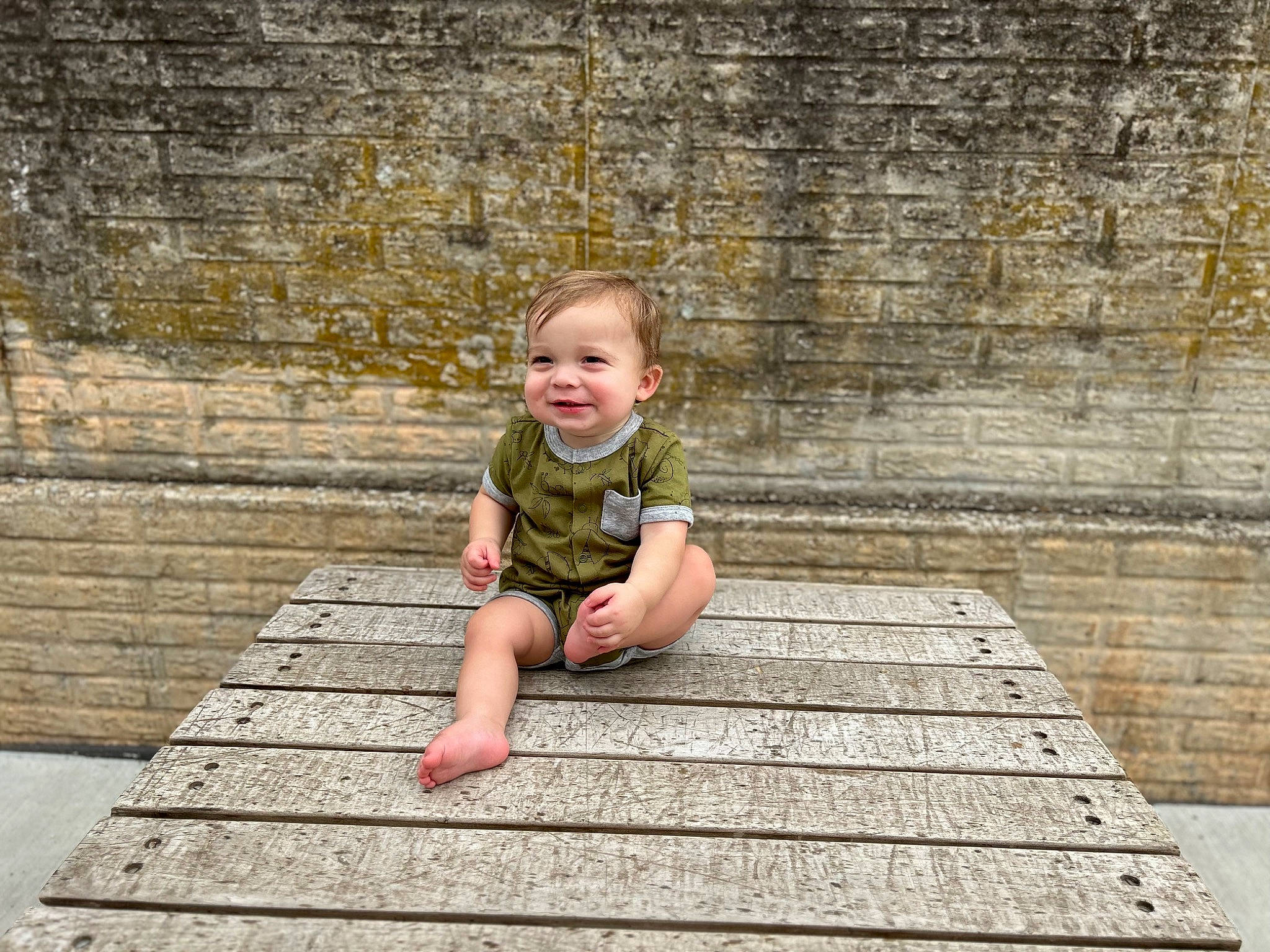 Ezra is registered to the contest to win money with this photo: baby, baby_toddler_clothing, brick, brickwork, child, cobblestone, flooring, fun, grass, happy, hardwood, joy, leisure, people_in_nature, person, road_surface, sitting, smile, toddler, vacation