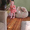 toddler, child, smiling, indoor, wooden_floor, bean_bag, cookie, furniture, person, home, orange_dress, barefoot, happy, living_room, man, table, background, cozy, casual, daylight