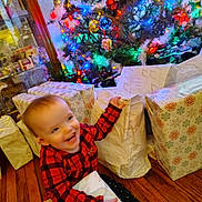 Penelope is registered to the contest to win money with this photo: toddler, child, christmas_tree, presents, holiday, red_plaid, wrapped_gifts, wooden_floor, smiling, happy, indoor, festive, decorations, colorful_lights, joyful, person, celebration, seasonal, family, home