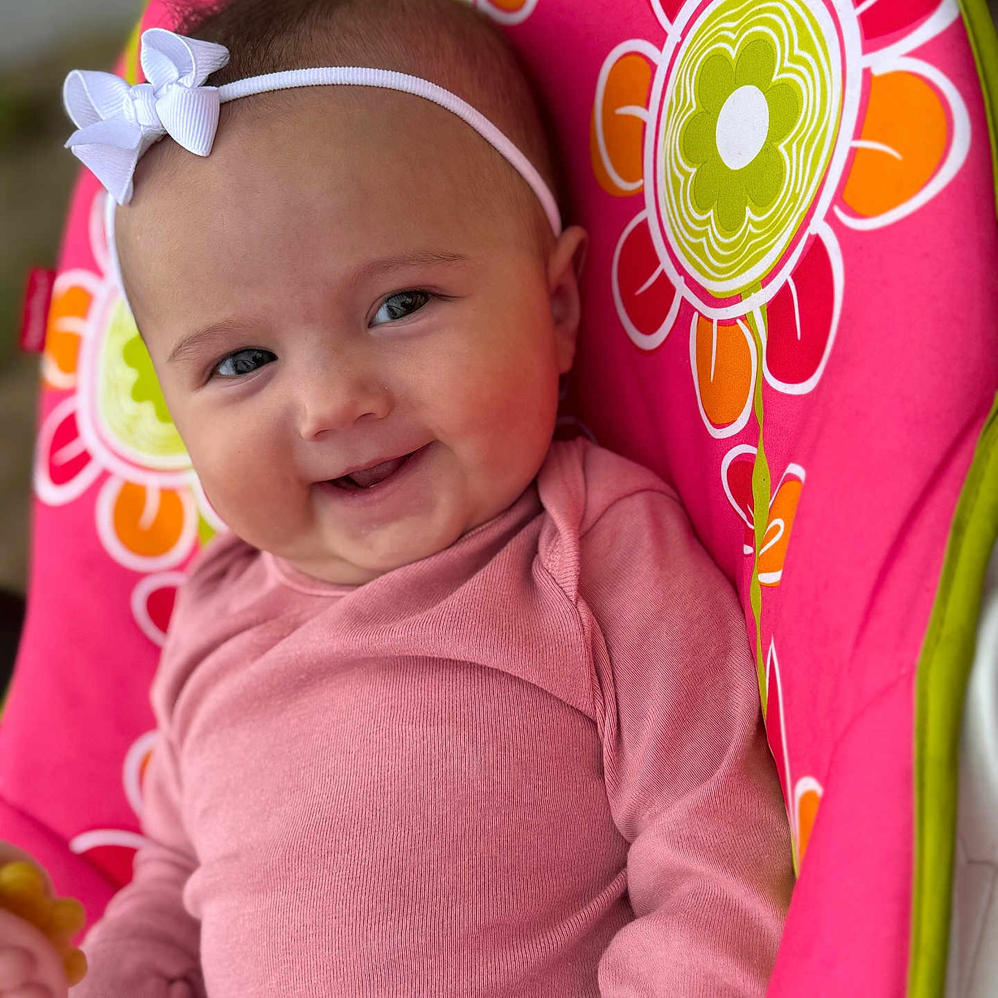 Renleigh joined the competition — help win amazing prizes! baby, baby_chair, baby_toy, child, closeup, cute, floral_pattern, happy, headband, indoors, infant, person, pink_clothing, playful, portrait, seatbelt, sitting, smiling, soft_lighting, young_child