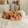 baby, sleeping, infant, headband, bow, blanket, brown_outfit, soft_light, cozy, indoors, bedroom, peaceful, newborn, cute, portrait, child, resting, white, fabric, calm