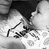 Brentlee joined the competition — help win amazing prizes! baby, adult, black_and_white, close_up, face, intimate, tender, onesie, cookie_pattern, child, person, portrait, couch, pillow, expression, love, family, interaction, monochrome, indoor