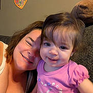 Ava is registered to the contest to win money with this photo: toddler, child, baby, adult, woman, mother, smiling, happy, portrait, selfie, couch, indoor, family, cuddle, pink_shirt, brown_hair, blue_eyes, heart_decoration, home, photograph