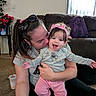 baby, child, adult, mother, smiling, laughing, portrait, indoor, living_room, couch, headband, pink_clothing, gray_shirt, sunglasses, backpack, flowers, window, artwork, family, cuddling