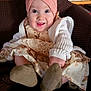 baby, infant, child, headband, flower, smile, big_eyes, dress, cardigan, socks, feet, blanket, chair, bookshelf, books, framed_photo, matryoshka, portrait, indoor, cozy