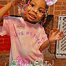 child, girl, smiling, easter, bunny_ears_filter, beads, candy, pink_shirt, brick_wall, decoration, indoor, carpet, toy, happy, posing, face_paint, festive, holiday, colorful, young