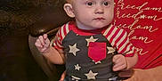 Valentino is registered to the contest to win money with this photo: baby, toddler, child, indoor, couch, jeans, shirt, stars, striped, person, smile, hand, face, foot, seated, curious, casual_clothing, adult, background, cozy