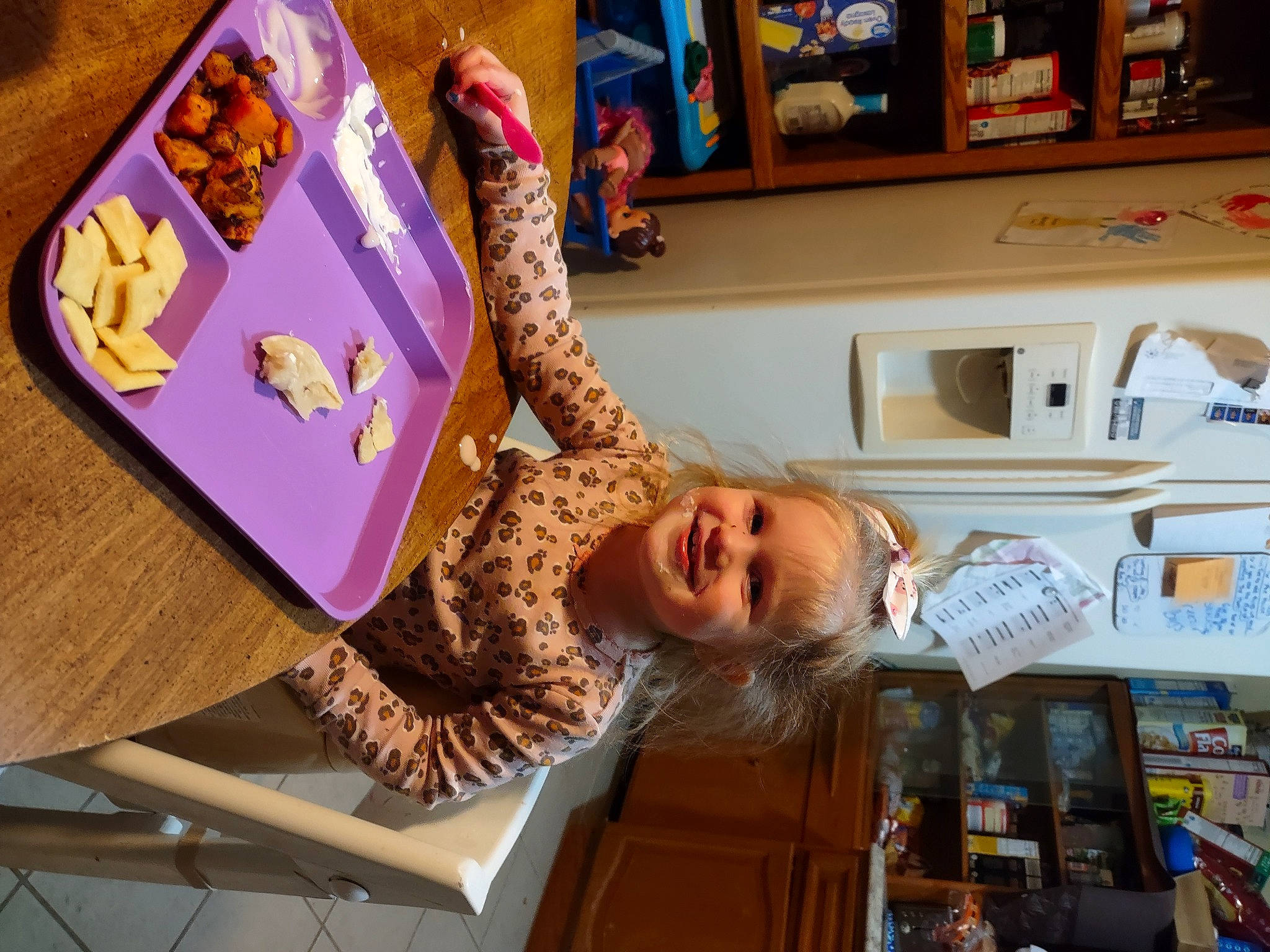 Auriel is registered to the contest to win money with this photo: bookcase, chair, child, fun, happy, home_appliance, joy, kitchen, kitchen_appliance, person, play, publication, refrigerator, room, shelf, shelving, sitting, smile, t_shirt, toddler