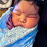 adult_holding_baby, baby, blanket, blue_blanket, cheeks, close_up, closed_eyes, cozy, face, fuzzy_blanket, hair, head, indoors, infant, newborn, peaceful, photograph, portrait, sleeping, swaddled