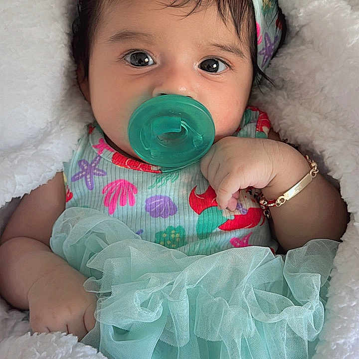 Sofía is registered to the contest to win money with this photo: adorable, baby, baby_girl, blanket, bracelet, closeup, clothing, colorful, comfort, cute, headband, indoors, infant, pacifier, portrait, resting, sleepwear, soft_texture, tulle, young_child