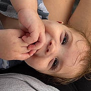 Rylan is registered to the contest to win money with this photo: baby, child, face, hand, fingers, eyes, skin, hair, lying_down, closeup, infant, curious, natural_light, portrait, expression, cute, soft, intimate, toddler, person