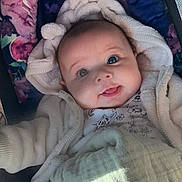 Aspyn joined the competition — help win amazing prizes! baby, blanket, child, clothing, cozy, cute, expression, face, hooded, indoors, infant, newborn, person, portrait, seat, smile, soft, toddler, warm, wrapped