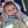 baby, blanket, blue_eyes, car_seat, child, clothing, comfort, cozy, cute, expression, face, indoors, infant, jacket, portrait, resting, smiling, soft_light, toddler, warm