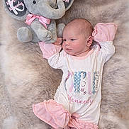 Kynzlee is registered to the contest to win money with this photo: newborn, baby, plush_toy, elephant, pink_clothing, white_clothing, fur_blanket, infant, soft_texture, cute, sleepy, child, portrait, lying_down, cozy, toy, decorative_text, baby_clothes, soft_lighting, peaceful