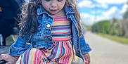 Eva a rejoint le concours — aidez-le/la à gagner de superbes lots ! child, girl, curly_hair, denim_jacket, striped_outfit, sneakers, outdoor, daylight, clouds, sky, vehicle, road, sidewalk, casual_clothing, cute, portrait, young_child, walking, nature, playful