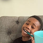 De Aire is registered to the contest to win money with this photo: black_shirt, brushing_teeth, child, couch, cup, dental_care, family, happy, hygiene, indoor, living_room, portrait, smartphone, smiling, table, toothbrush, toothpaste, turquoise, video_call, wood