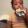 De Onni joined the competition — help win amazing prizes! toddler, child, baby, portrait, face, sitting, bed, bedroom, snack, food_pouch, eating, indoor, facetime, smartphone, digital_interface, casual_clothing, diaper, blanket, dark_skin, household
