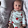Jade participe au concours pour gagner de l'argent avec cette photo : baby, infant, onesie, hearts, blanket, lying_down, cute, smile, face, skin, hand, leg, soft_texture, fabric, child, portrait, newborn, clothing, indoors, comfort