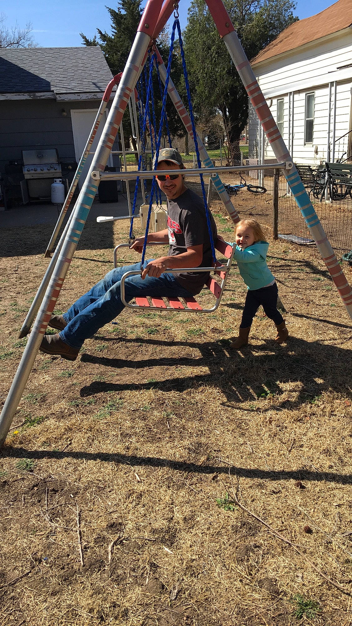 Chevelle is registered to the contest to win money with this photo: city, fun, grass, headwear, human_settlement, joy, leisure, outdoor_play_equipment, person, plant, play, playground, public_space, recreation, soil, swing, tree