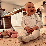 Emy a rejoint le concours — aidez-le/la à gagner de superbes lots ! baby, child, smiling, sitting, play_mat, stuffed_toy, minnie_mouse, toy, kitchen, floor, sock, white_clothing, happy, indoor, furniture, refrigerator, cabinet, wood, person, cute