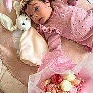 Camelia participe au concours pour gagner de l'argent avec cette photo : baby, infant, pink_clothing, headband, plush_toy, bunny, blanket, flower_bouquet, flowers, soft_texture, lying_down, cute, child, portrait, indoor, pastel_colors, decor, hand, face, young_child