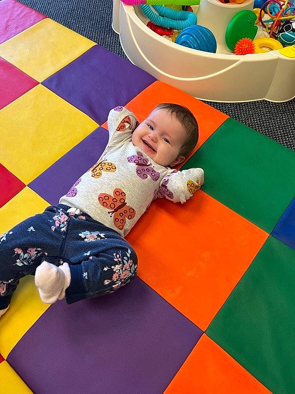 Hope is registered to the contest to win money with this photo: baby, baby_playing_with_toys, baby_toddler_clothing, baby_toys, child, floor, flooring, fun, happy, joy, leisure, pattern, person, play, playmat, purple, recreation, room, smile, textile