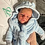 Mercier is registered to the contest to win money with this photo: baby, infant, person, clothing, robe, hood, hand, couch, fabric, soft_texture, indoor, comfort, cute, relaxed, wrapped, blue, white, gray, newborn, portrait
