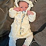 baby, infant, pacifier, hooded_jacket, white_clothing, striped_pants, barefoot, couch, blanket, beaded_chain, cozy, indoor, child, cute, comfort, relaxing, furniture, portrait, small_person, home
