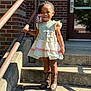 child, girl, smiling, dress, cowboy_boots, stairs, handrail, brick_wall, outdoor, sunlight, shadow, concrete, building, door, beads, hair_accessory, happy, portrait, person, standing