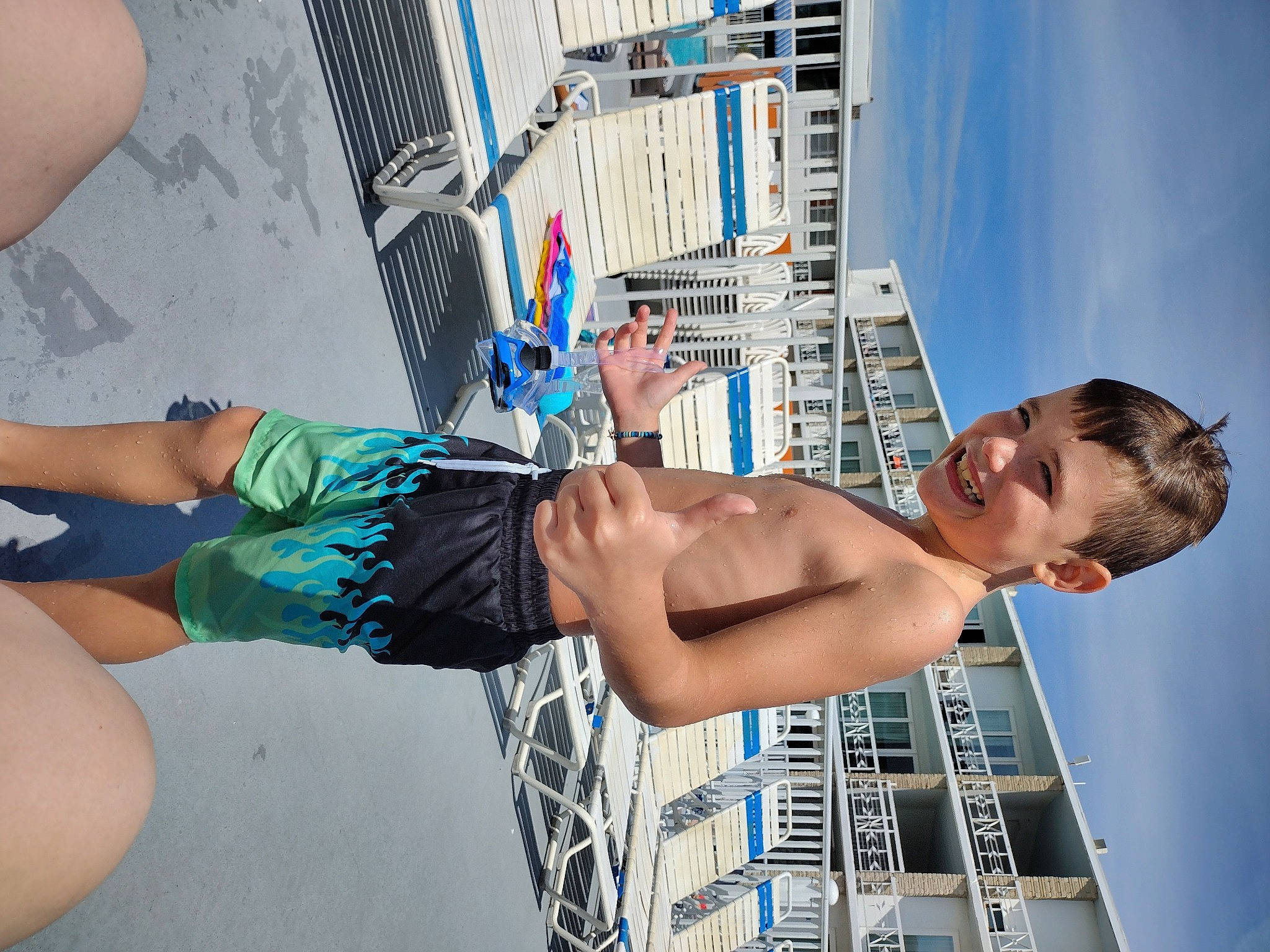 Cyrus is registered to the contest to win money with this photo: abdomen, barechested, blue, board_short, brassiere, chest, elbow, electric_blue, fun, human_leg, joy, leisure, person, recreation, shorts, sky, swimming_pool, swimwear, thigh, trunk