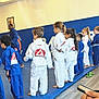 Mathias joined the competition — help win amazing prizes! children, martial_arts, jiu_jitsu, blue_uniform, white_uniform, line, indoors, mat, training, barefoot, person, group, sport, young, kids, class, coach, floor, hand, phone