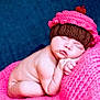 baby, newborn, sleeping, knitted_hat, cupcake_hat, pink_blanket, blue_background, soft_texture, cute, infant, resting, cozy, peaceful, portrait, child, skin, hand, face, closed_eyes, lying_down