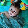 baby, blanket, pacifier, toy, mirror, play_mat, plush_toy, colorful, infant, child, cute, face, expression, soft_texture, fabric, indoor, portrait, looking_up, wrapped, comfort